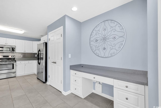 389 Barton Loop, Myrtle Beach, SC 29579 - kitchen with appliances with stainless steel finishes, white cabinetry, light tile patterned floors, decorative backsplash, and dark countertops
