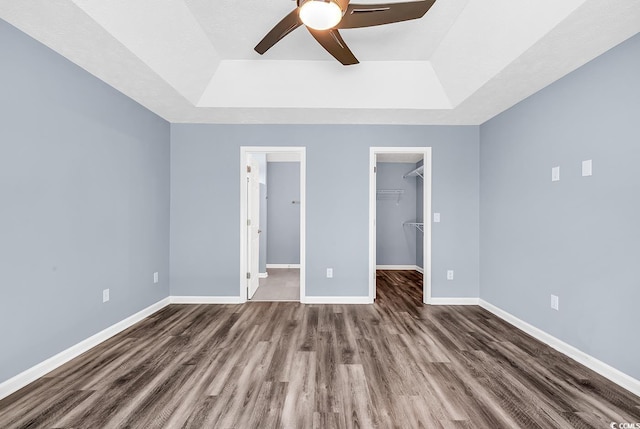 389 Barton Loop, Myrtle Beach, SC 29579 - unfurnished bedroom featuring a raised ceiling, dark wood-type flooring, baseboards, and a spacious closet