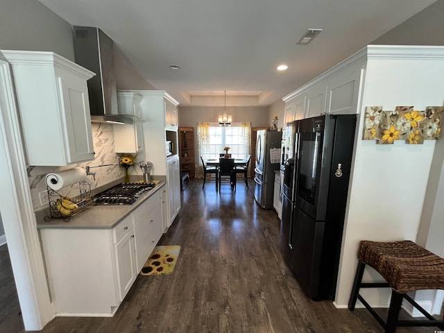 4008 Tupelo Ct, Conway, SC 29526 - kitchen featuring appliances with stainless steel finishes, dark wood finished floors, a raised ceiling, white cabinets, and a chandelier