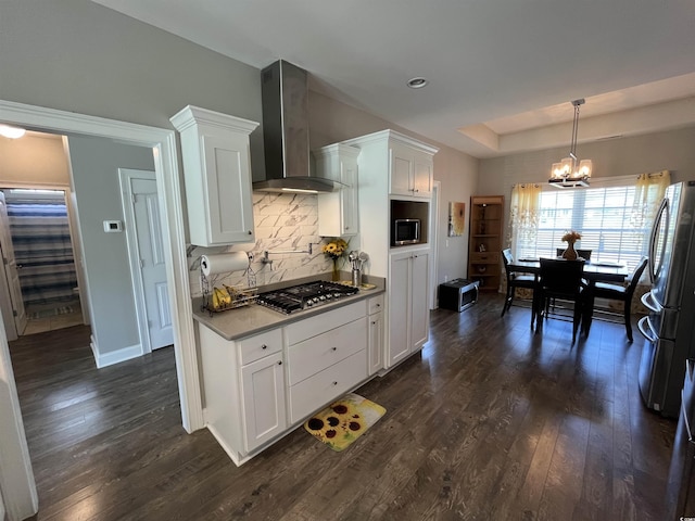 kitchen featuring stainless steel appliances, an inviting chandelier, dark wood finished floors, and wall chimney exhaust hood