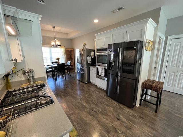 kitchen featuring visible vents, an inviting chandelier, dark wood-style flooring, white cabinets, and stainless steel appliances