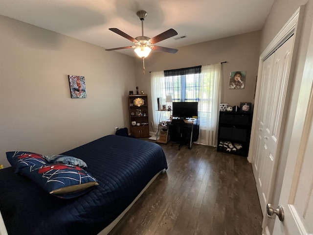 bedroom with visible vents, ceiling fan, wood finished floors, and a closet