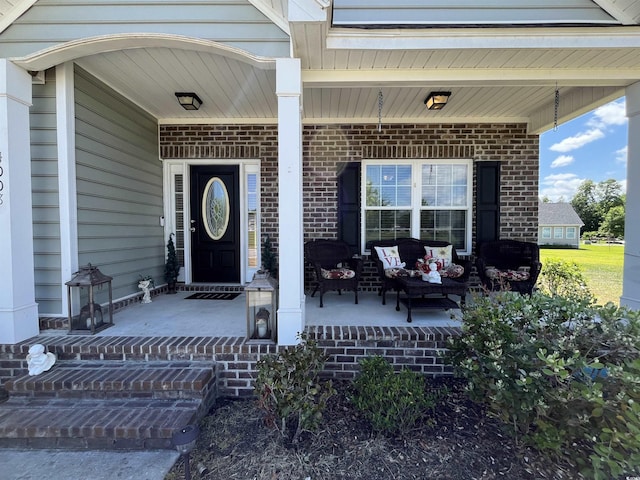 entrance to property featuring brick siding and covered porch