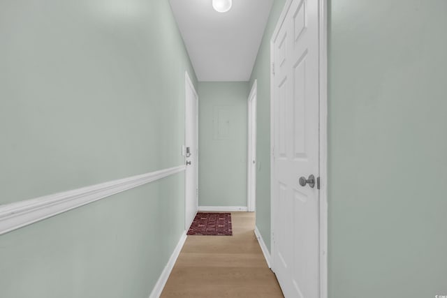 hall featuring baseboards and light wood finished floors