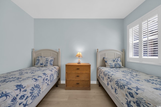 bedroom with baseboards and wood finished floors