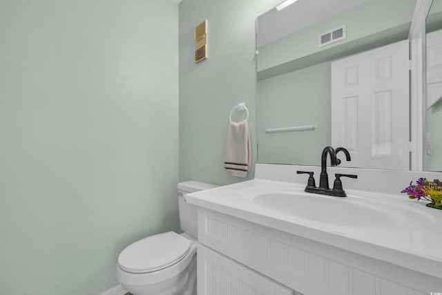 half bathroom featuring visible vents, toilet, and vanity