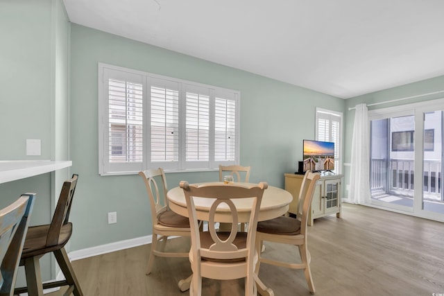 dining room with baseboards and light wood-style flooring