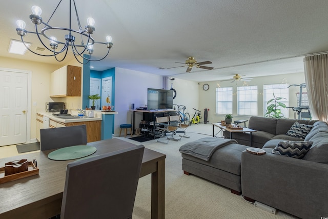 carpeted living room featuring a sink and ceiling fan with notable chandelier