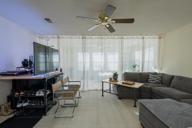 carpeted living room featuring a textured ceiling, ceiling fan, and visible vents