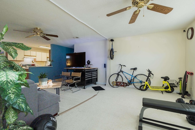 living room featuring ceiling fan, carpet, and a textured ceiling