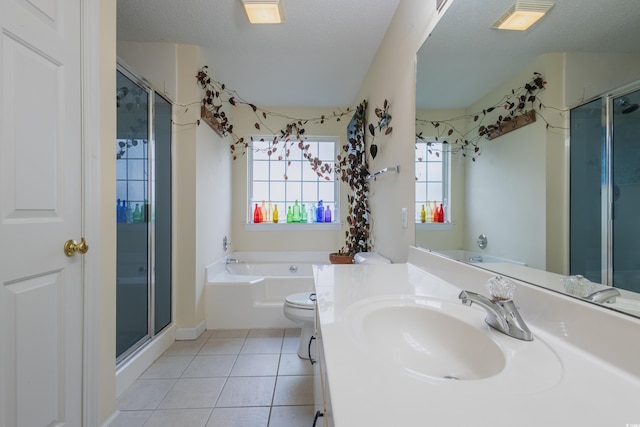 bathroom with a bath, a textured ceiling, a shower stall, vanity, and tile patterned floors