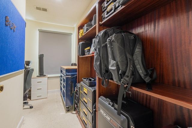 walk in closet featuring light colored carpet and visible vents