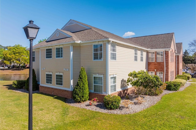 view of home's exterior featuring a lawn and roof with shingles