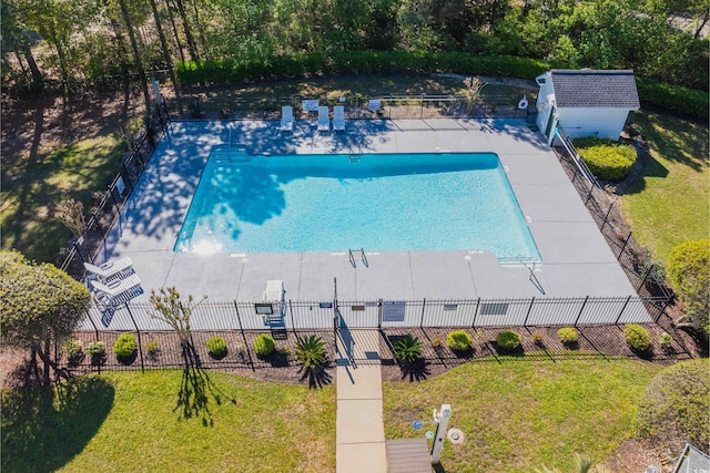 community pool featuring a lawn and fence