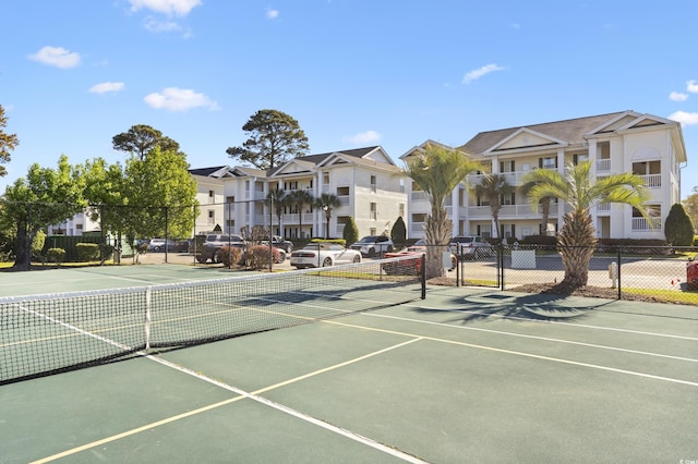 view of sport court with fence and a residential view