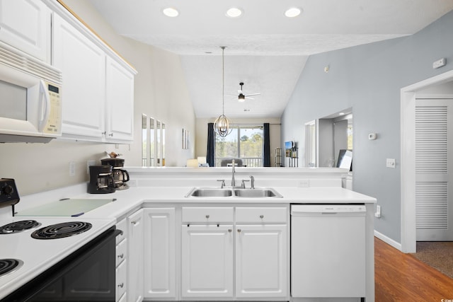 kitchen featuring lofted ceiling, white appliances, light countertops, white cabinets, and a sink