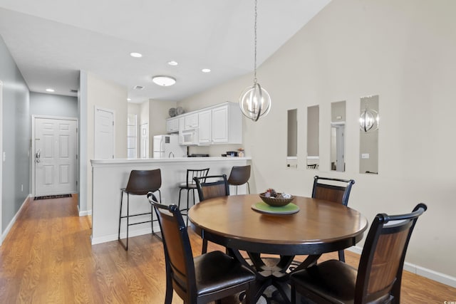 dining area featuring light wood-style floors, recessed lighting, baseboards, and a chandelier