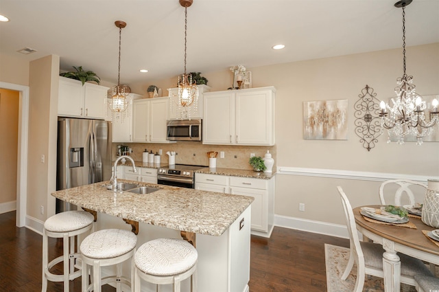 kitchen featuring baseboards, tasteful backsplash, a sink, dark wood finished floors, and stainless steel appliances