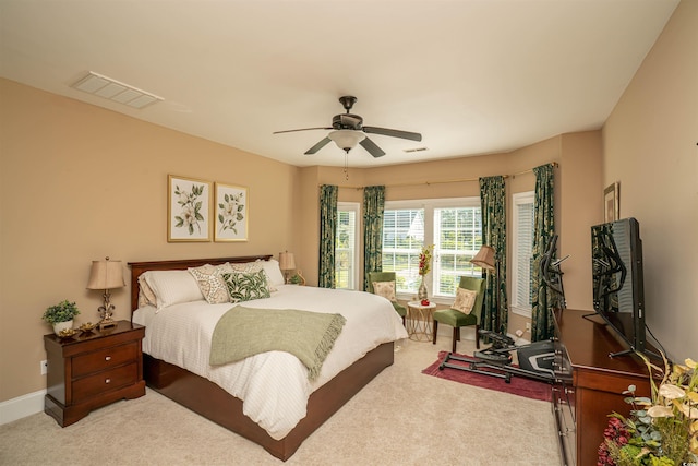 bedroom featuring baseboards, a ceiling fan, light colored carpet, and visible vents