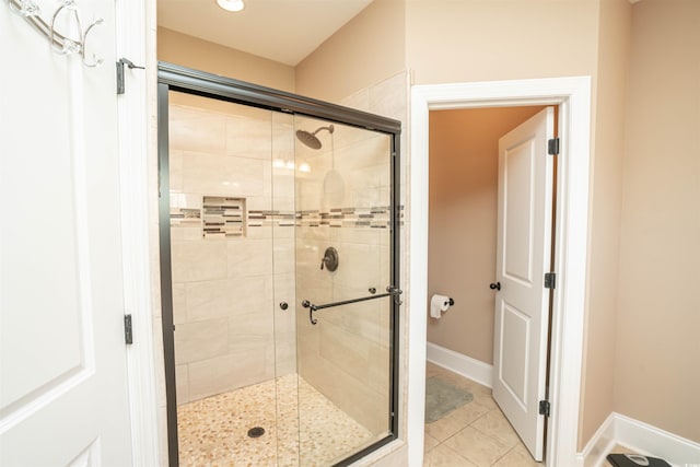full bath with baseboards, tile patterned floors, and a shower stall