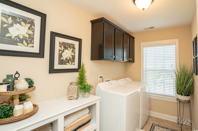laundry area with visible vents, baseboards, washer and clothes dryer, cabinet space, and light tile patterned floors