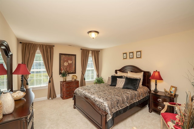 bedroom with baseboards and light colored carpet