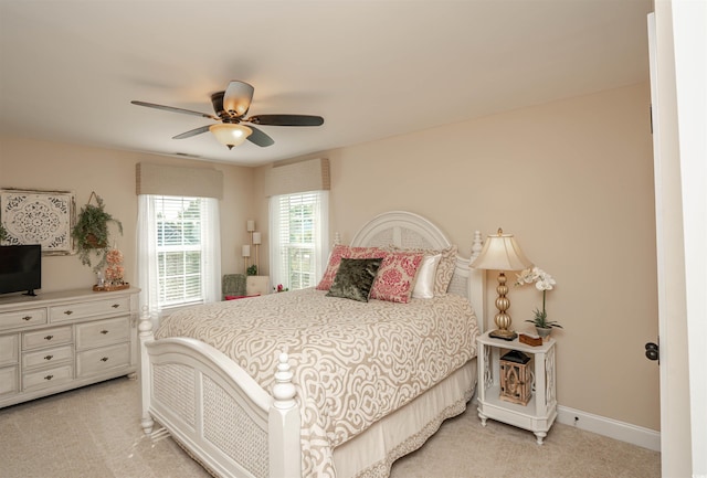 bedroom featuring ceiling fan, light carpet, and baseboards