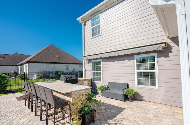 view of patio / terrace with fence, outdoor dry bar, and grilling area