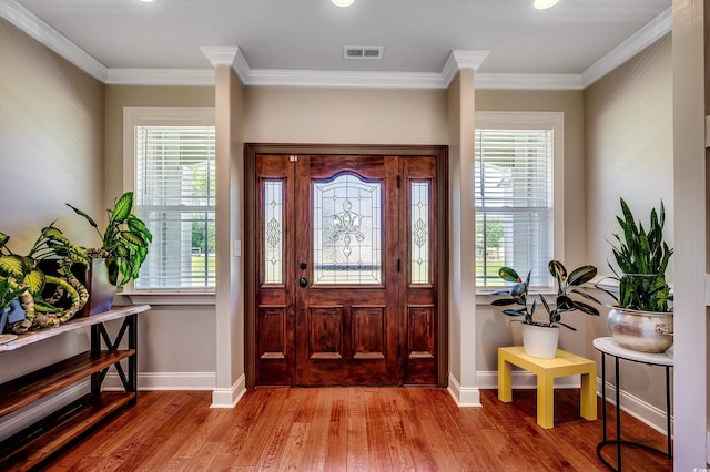 foyer with visible vents, baseboards, wood finished floors, and a healthy amount of sunlight