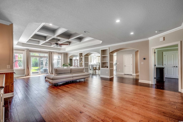 living room featuring crown molding, arched walkways, a textured ceiling, and ceiling fan