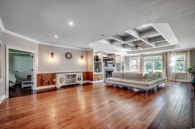 living room featuring ornamental molding, a textured ceiling, a ceiling fan, and hardwood / wood-style flooring