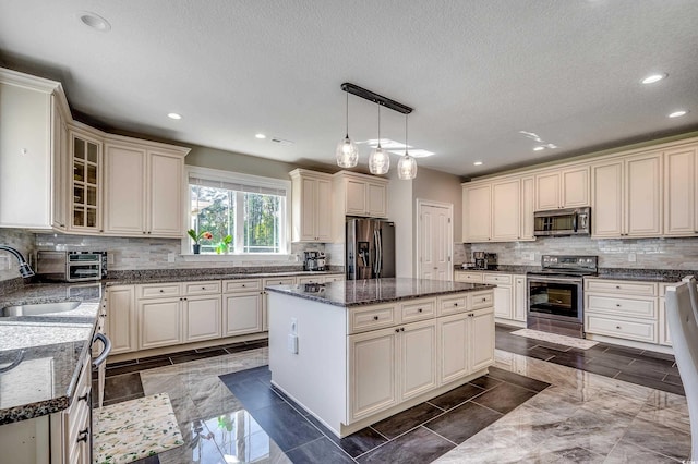 kitchen with backsplash, recessed lighting, appliances with stainless steel finishes, and a center island