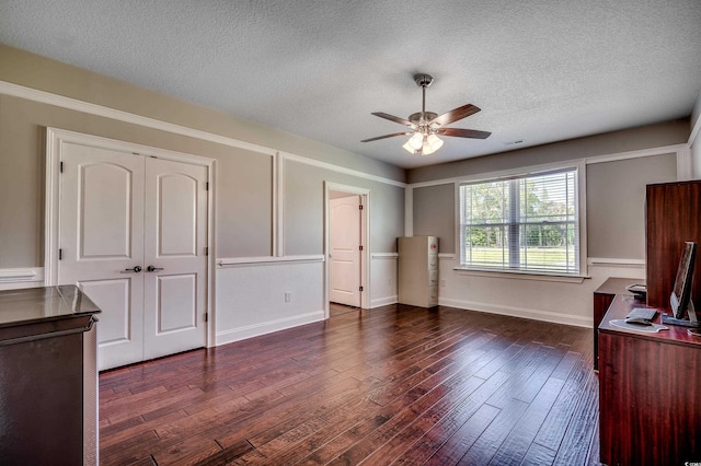 unfurnished living room featuring a textured ceiling, dark wood finished floors, a ceiling fan, baseboards, and visible vents