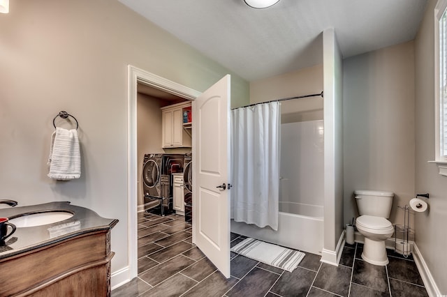 full bath featuring shower / bath combination with curtain, washing machine and clothes dryer, baseboards, vanity, and toilet