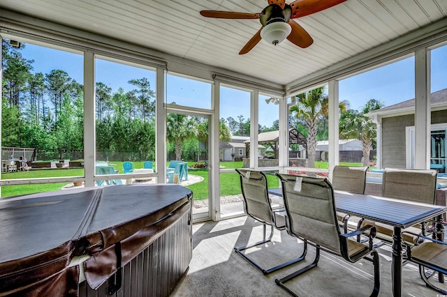 sunroom / solarium with a ceiling fan and outdoor dining space