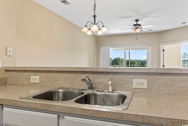 kitchen featuring a sink, decorative light fixtures, light countertops, a ceiling fan, and white cabinetry