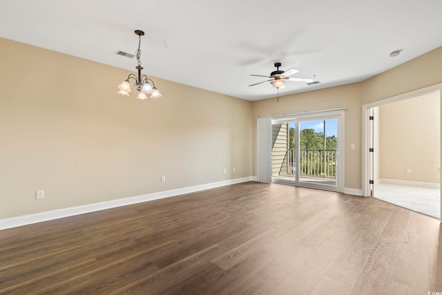 spare room with a ceiling fan, wood finished floors, baseboards, and a chandelier