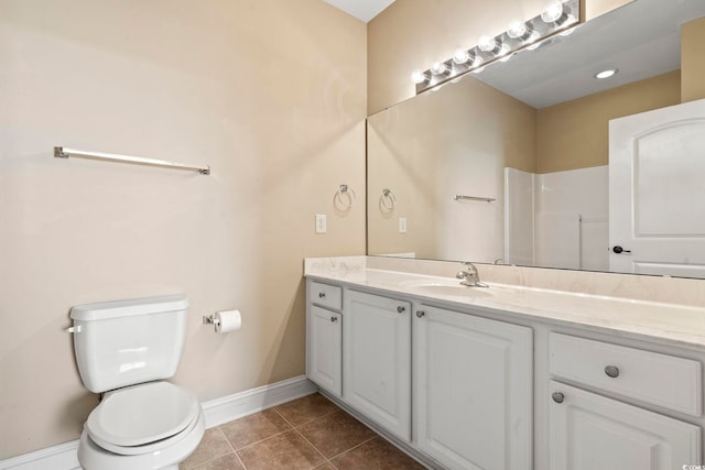 bathroom with tile patterned flooring, toilet, vanity, and baseboards