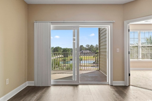 doorway with baseboards, wood finished floors, and a water view
