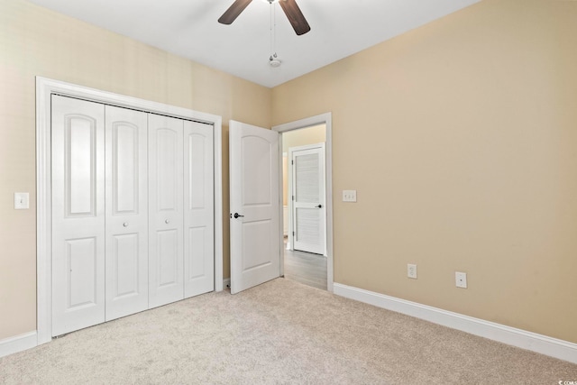 unfurnished bedroom with carpet, baseboards, a closet, and ceiling fan