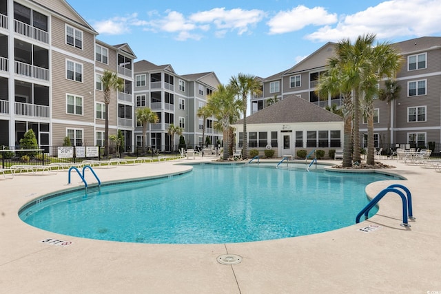 community pool featuring fence and a patio area