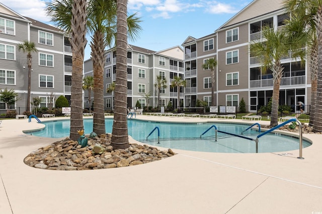 community pool featuring fence and a patio area