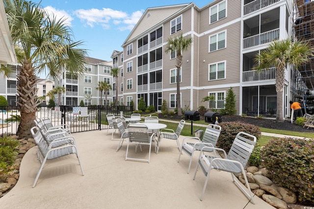 view of property's community featuring fence, a patio, and outdoor dining area