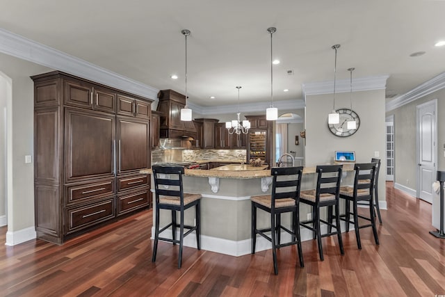 256 Shoreward Dr, Myrtle Beach, SC 29579 - kitchen featuring a breakfast bar, light stone countertops, dark wood-type flooring, a chandelier, and tasteful backsplash