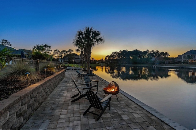 256 Shoreward Dr, Myrtle Beach, SC 29579 - patio terrace at dusk with a water view, fence, and a fire pit