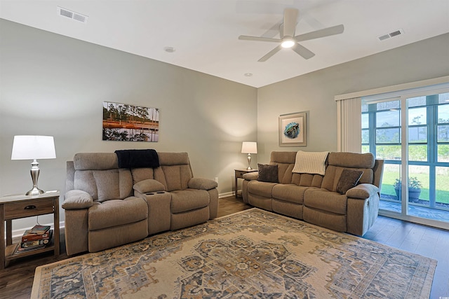 living area featuring a ceiling fan, baseboards, visible vents, and dark wood-style floors