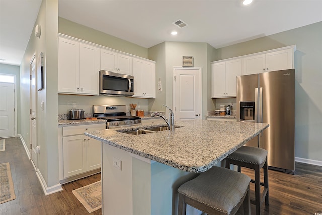kitchen with visible vents, a sink, baseboards, dark wood-style floors, and stainless steel appliances