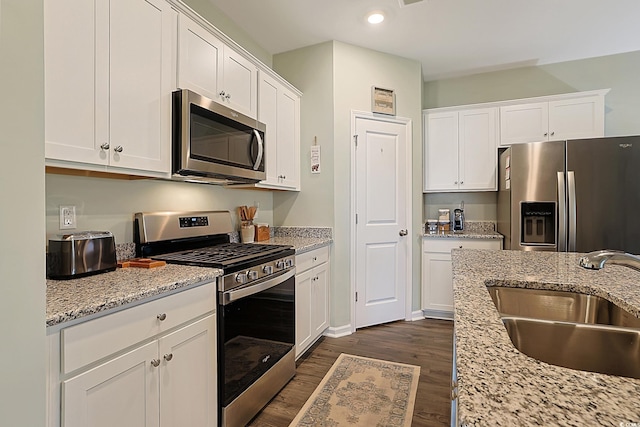 kitchen featuring dark wood-type flooring, a sink, white cabinetry, and stainless steel appliances