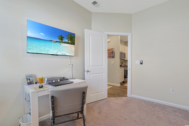 carpeted office space with baseboards and visible vents