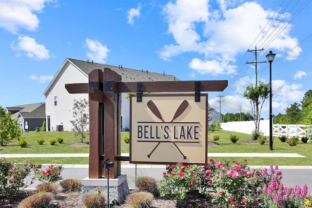 community sign with fence and a lawn